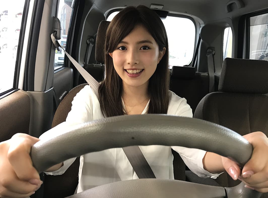 運転席でハンドルを握る笑顔の女性｜タイヤ館