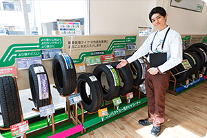 展示されているタイヤとそれを紹介するスタッフ｜タイヤ館