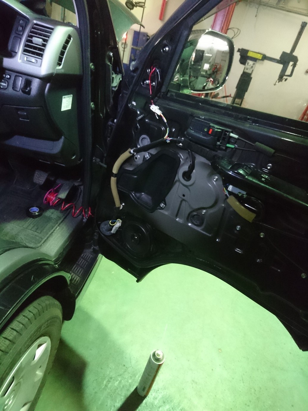 配線をドアから車内に引き回す作業中の写真